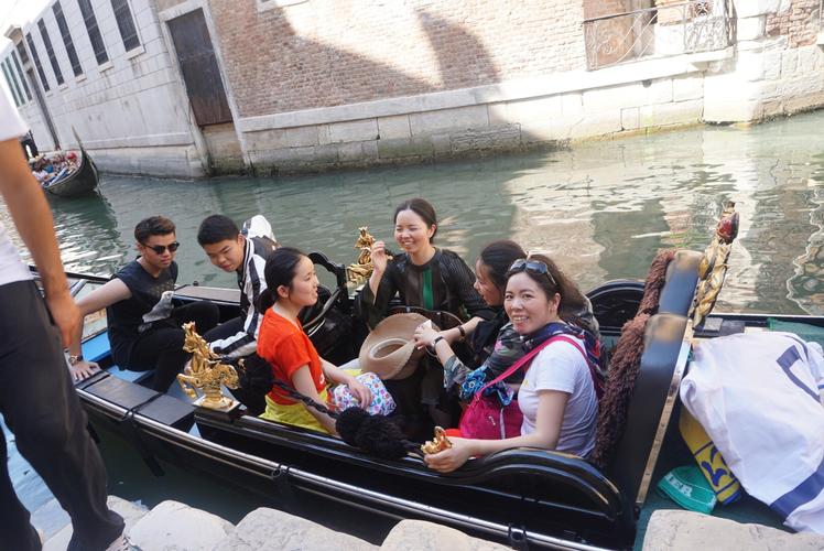 人们坐威尼斯的小艇做生意（威尼斯的小艇白天人们坐小艇）